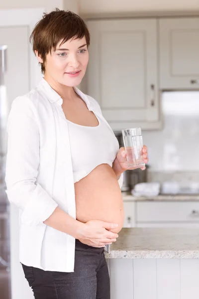 Femme enceinte buvant un verre d'eau — Photo