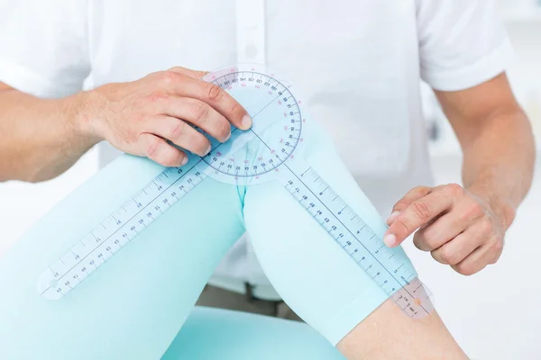 Médico midiendo rodilla con goniómetro —  Fotos de Stock