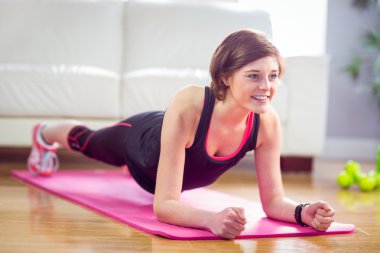 Fit woman doing plank on mat clipart
