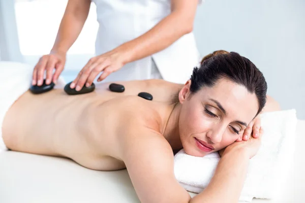 Sorrindo morena recebendo massagem de pedra quente — Fotografia de Stock