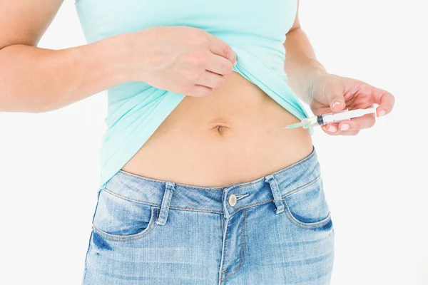 Woman injecting fluid in her stomach — Stock Photo, Image