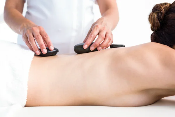 Brunett får massage med varma stenar — Stockfoto