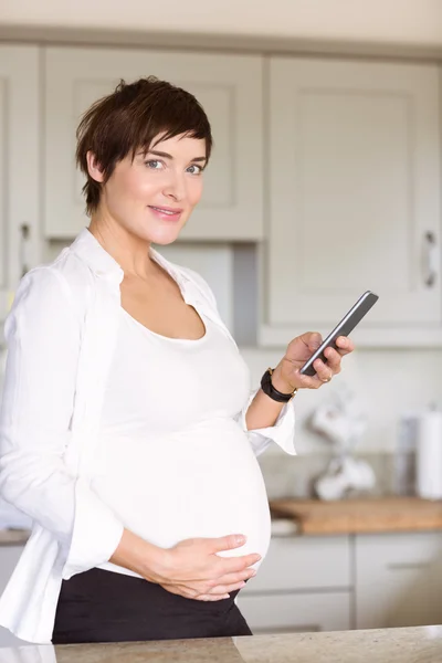 Mulher grávida usando seu smartphone — Fotografia de Stock