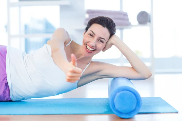 Lächelnde Frau liegt auf Gymnastikmatte — Stockfoto