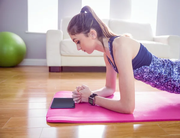 Fitte Frau beim Planken auf Matte — Stockfoto