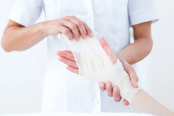 Médecin bandage de son poignet patient — Photo