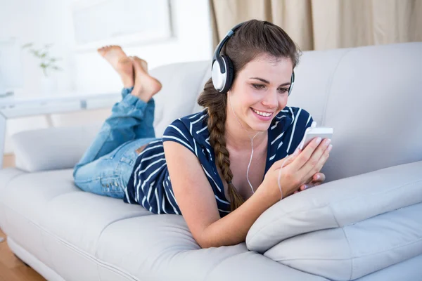 Brunette luisteren muziek met smartphone — Stockfoto