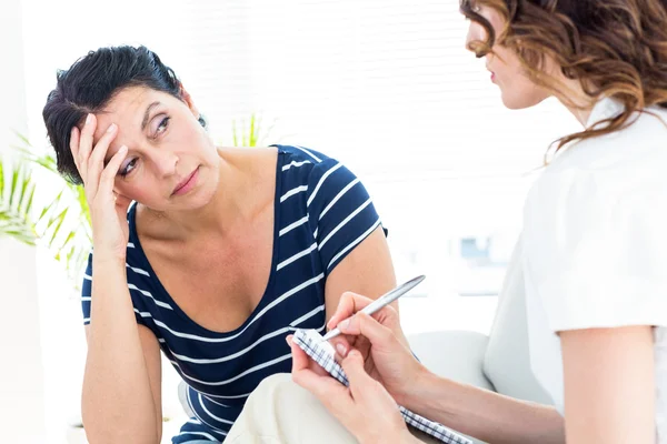 Terapeuten lyssnar hennes patient och ta anteckningar — Stockfoto