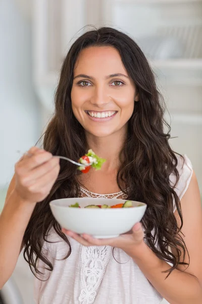 Mooie brunette eten van een salade — Stockfoto