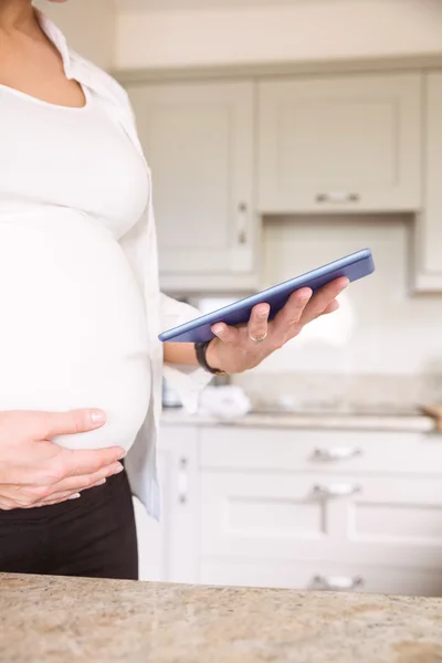 Беременная женщина с планшетным ПК — стоковое фото