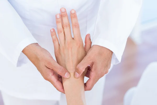 Arts behandeling van haar patiënten pols — Stockfoto