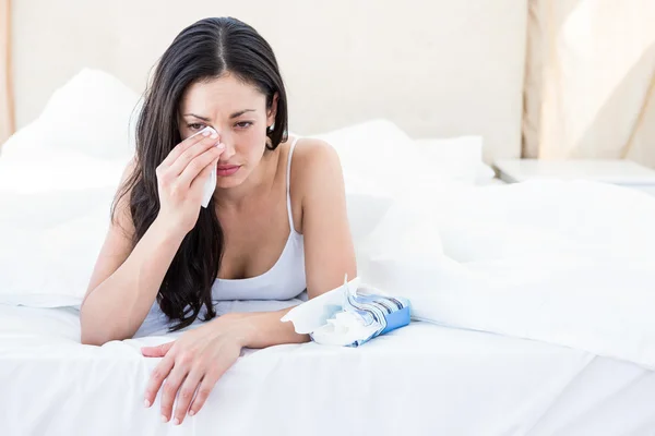 Pretty brunette crying on bed — Stock Photo, Image