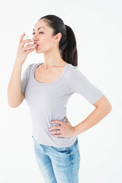 Asthmatic pretty brunette using inhaler — Stock Photo, Image