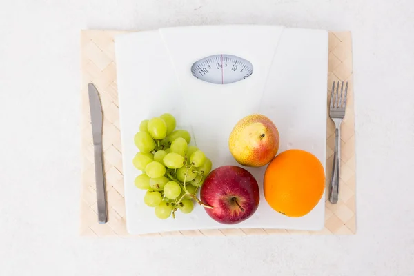 Pesaje de escamas con frutas —  Fotos de Stock