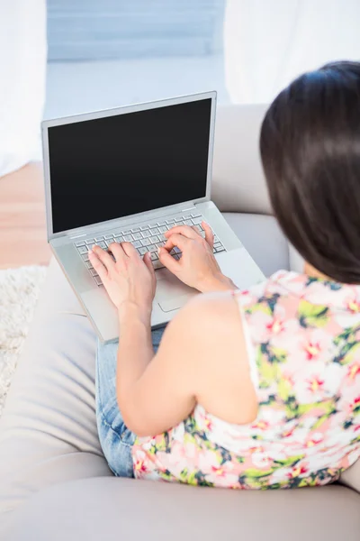 Szép barna használ laptop kanapén — Stock Fotó