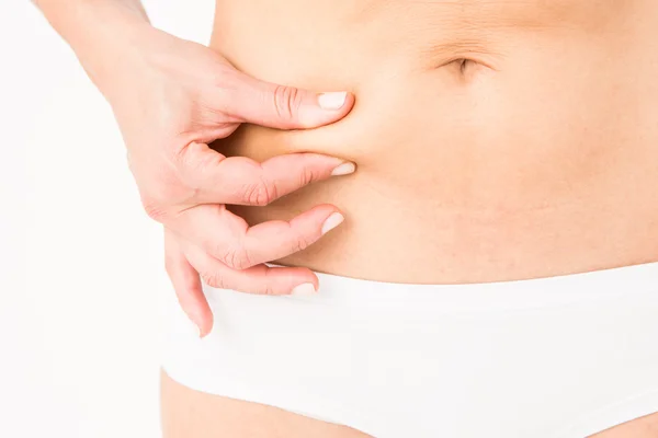 Mujer en forma pellizcándose el estómago —  Fotos de Stock