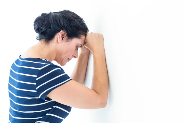 Sad woman leaning against the wall — Stock Photo, Image