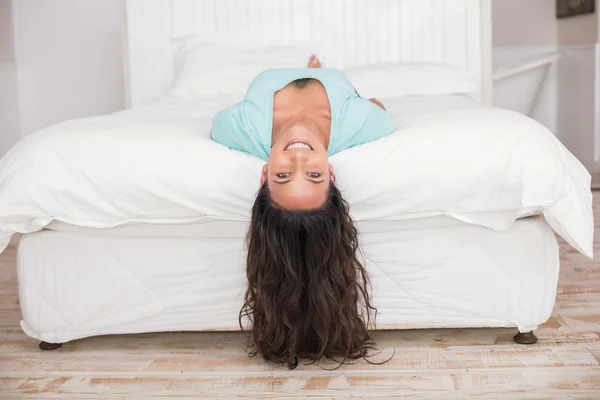 Szczęśliwy brunetka leżąc na łóżku — Zdjęcie stockowe
