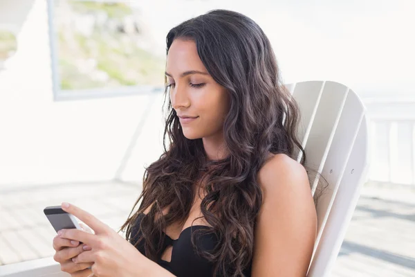 Mooie brunette vergadering op een stoel — Stockfoto