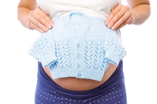Mulher grávida segurando roupas de bebê — Fotografia de Stock