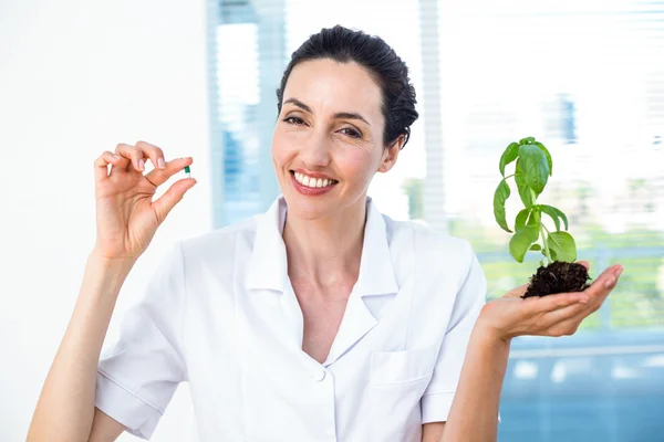 Wetenschapper holding basilicum plant en pil — Stockfoto