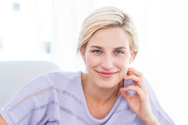 Hübsche blonde Frau entspannt sich auf der Couch — Stockfoto