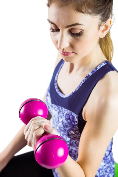 Fit woman lifting pink dumbbell — Stock Photo, Image