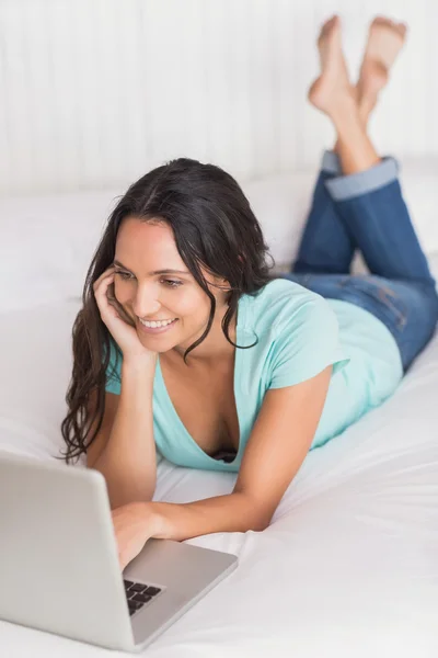 Morena feliz usando seu laptop — Fotografia de Stock