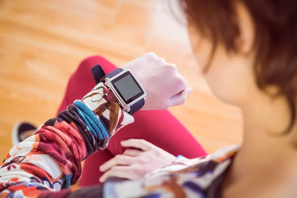 Slim woman looking at her smart watch — Stock Photo, Image
