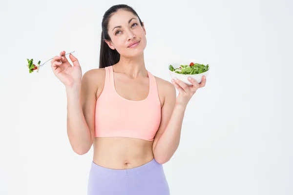 Leende brunett äta sallad — Stockfoto