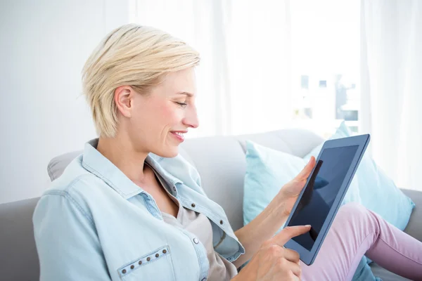 Blonde vrouw op de Bank met behulp van Tablet PC — Stockfoto