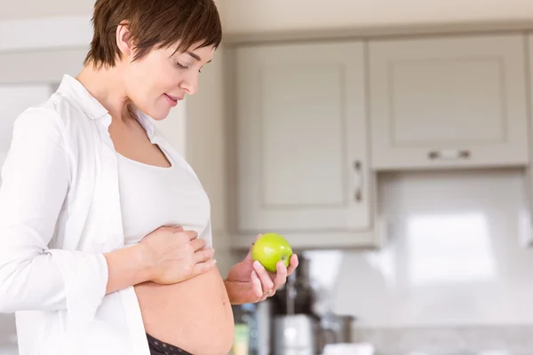 Zwangere vrouw met een appel — Stockfoto