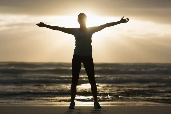 Sportliche Brünette Stretching am Strand — Stockfoto