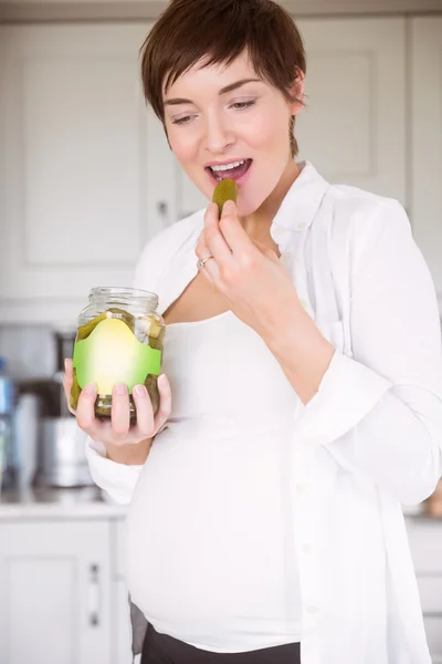 Pregnant woman eating jar of pickles — Stock Photo, Image