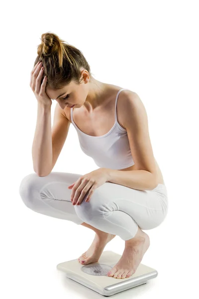 Slim woman disappointed on scales — Stock Photo, Image