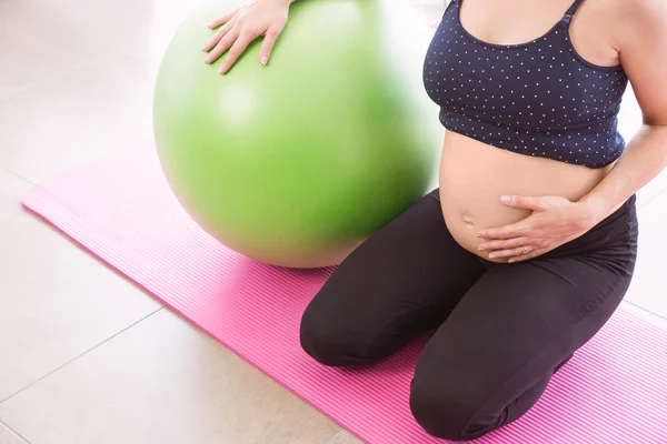 Zwangere vrouw houden in vorm — Stockfoto