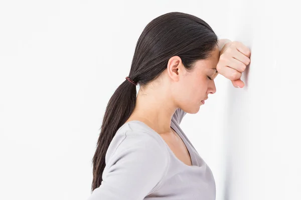 Triest vrouw leunend tegen de muur — Stockfoto