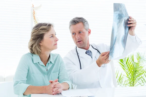 Доктор показывает рентген своему пациенту — стоковое фото