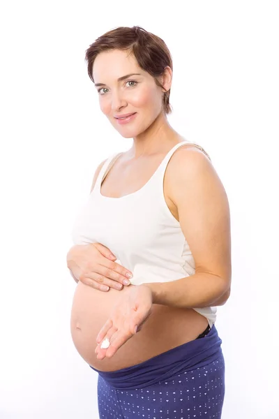 Mulher grávida mostrando creme corporal — Fotografia de Stock