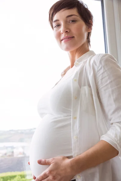 怀孕的妇女抱着她的肚子 — 图库照片
