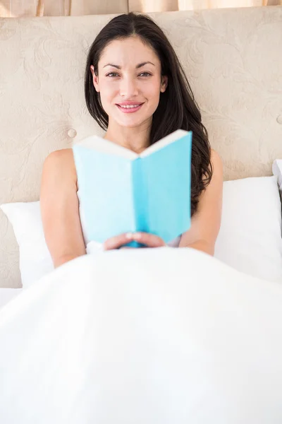 Όμορφη μελαχρινή ανάγνωση στο κρεβάτι — Φωτογραφία Αρχείου