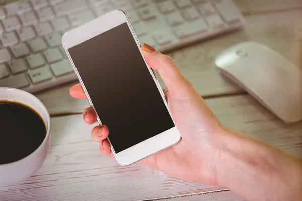 Donna utilizzando il suo smartphone e tastiera — Foto Stock