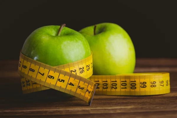 Green apples with measuring tape — Stock Photo, Image