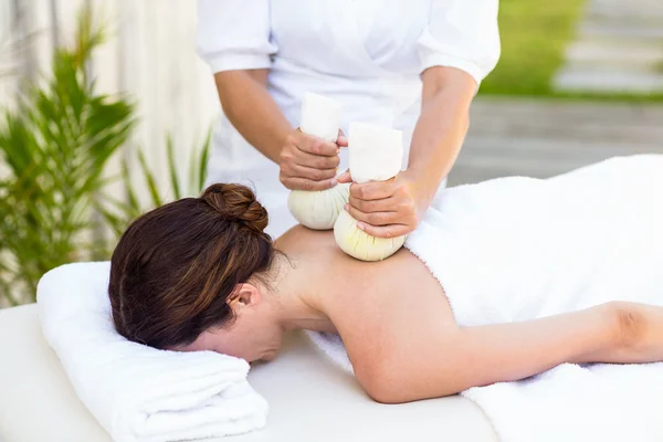 Morena com massagem com compressas de ervas — Fotografia de Stock