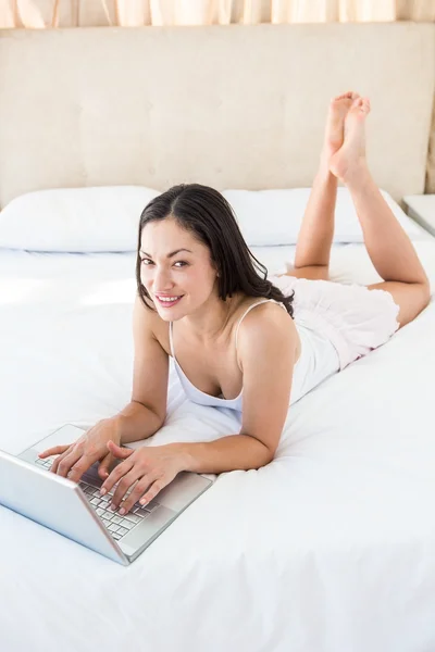 Půvabná brunetka na posteli — Stock fotografie