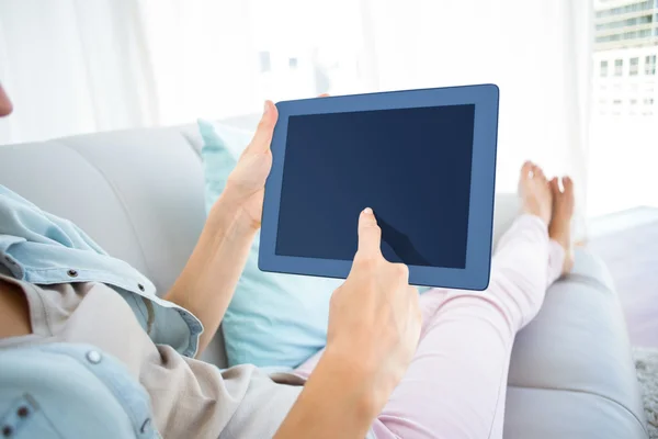 女人在沙发上使用她的平板电脑 — 图库照片
