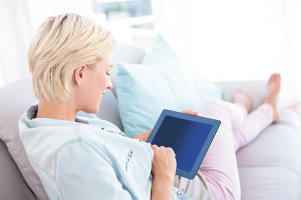 Blonde woman using tablet on the couch — Stock Photo, Image