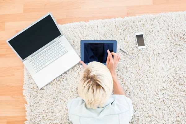 Donna sul pavimento utilizzando il suo computer portatile e tablet — Foto Stock