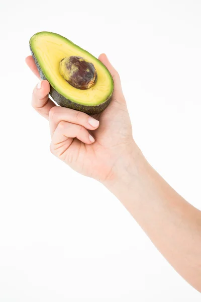 Donna che tiene metà di un avocado — Foto Stock