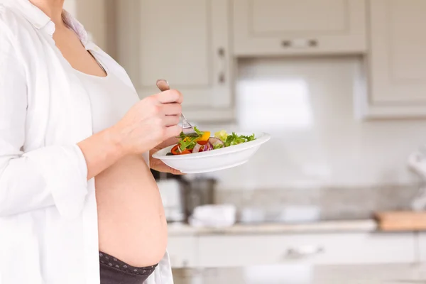 Mujer embarazada comiendo una ensalada — Foto de Stock